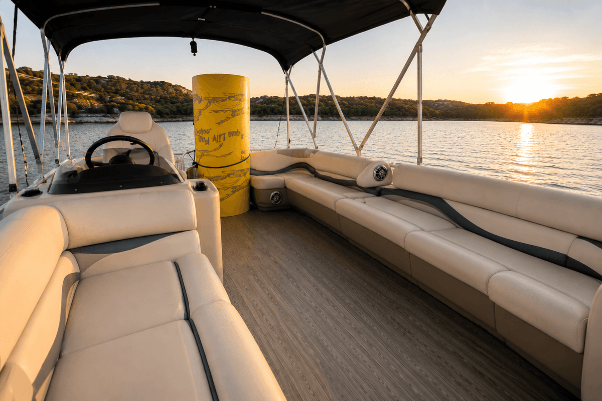 Plush cream seating and Aqua Lily Pad on a BOATX pontoon boat deck at golden hour sunset on Lake Austin