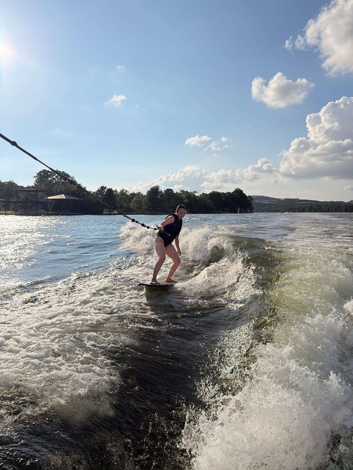 Woman wakesurfing behind a boat on Lake Austin Texas