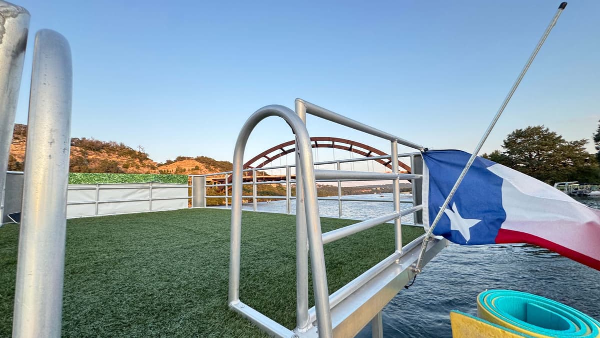 Party barge top deck with Texas flag Pennybacker Bridge Lake Austin